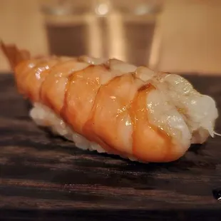 a piece of sushi on a chopping board