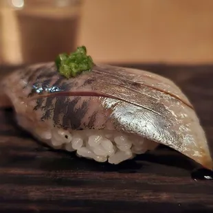a piece of sushi on a chopping board