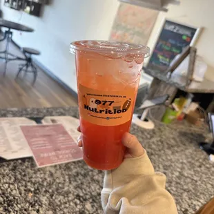 a person holding a cup of juice