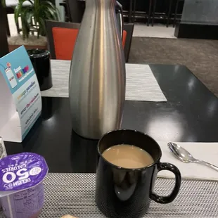 a table with a cup of coffee and a bagel
