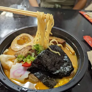 a bowl of ramen with chopsticks