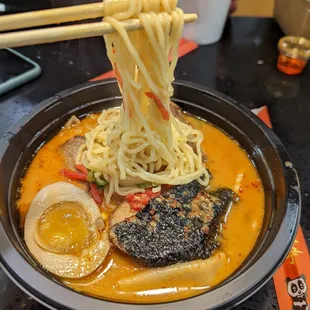 a bowl of ramen noodles with chopsticks