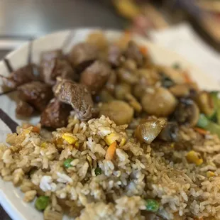 a plate of rice with meat and vegetables