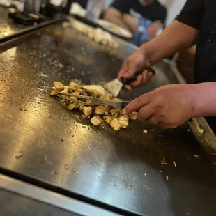 a chef cutting mushrooms on a grill