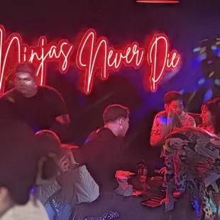 a neon sign that says ninjas never die