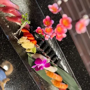 a variety of sushi on a black plate