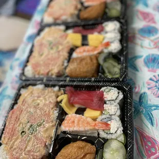 three trays of different types of sushi