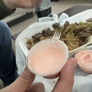 a person holding a plastic container of food