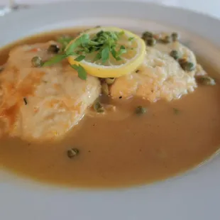 Nino&apos;s Authentic Italian Cuisine Pollo Piccata Dish with lemon butter sauce, capers, and fresh lemon.