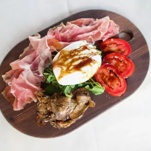 Nino&apos;s Authentic Italian Cuisine Burrata Antipasti with creamy Italian mozzarella served with prosciutto roasted vegetables a...