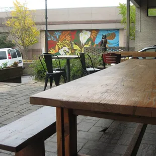 a table and benches in front of a mural