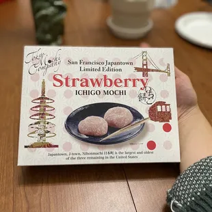 a person holding a box of strawberries