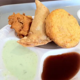 Mirch Pakora, Veggie Samosa, Aalloo Tiki with green yogurt and sweet spice sauces.