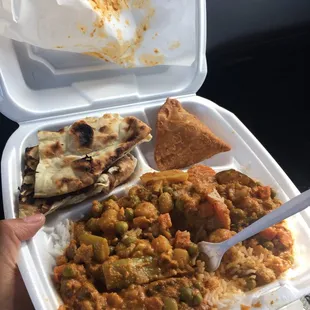 Vegetable Curry on top of White Rice with naan (super fluffy and good) and some fried dish with potatos and chickpeas in it.