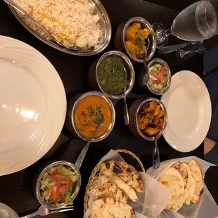 Pilaf rice, alu gobi, saag paneer, butter chicken, chicken tikka, (regular) naan, and garlic naan.