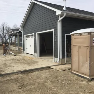 a portable toilet in front of a garage