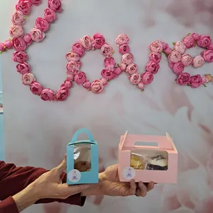 two hands holding a box of cake