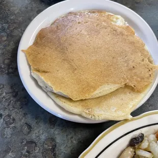 a plate of pancakes and a plate of hash browns