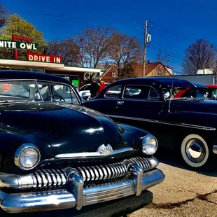 two classic cars parked in a parking lot