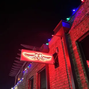 a neon sign on a brick building