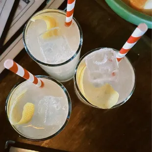 three glasses of lemonade with straws