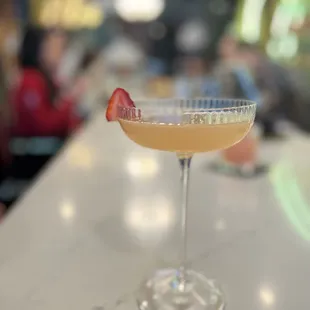 a cocktail with a strawberry garnish