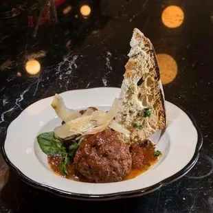 a plate of meatballs and a piece of bread