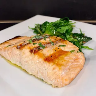 Grilled salmon entrée served with sautéed spinach