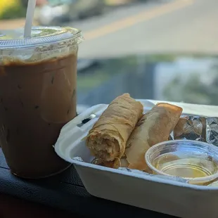 a cup of iced coffee and a sandwich in a styrofoam