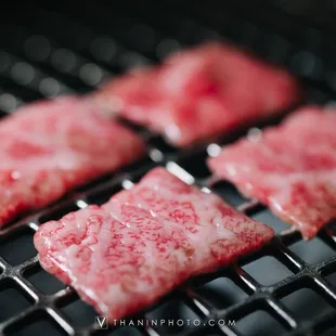 four pieces of meat on a grill