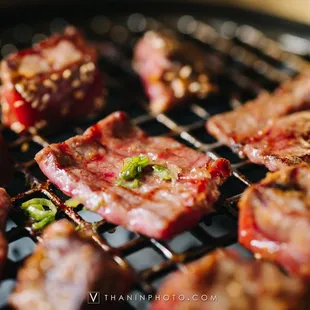 steaks cooking on a grill