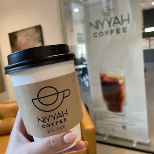 a hand holding a cup of coffee