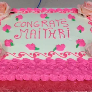 a pink and white cake with roses