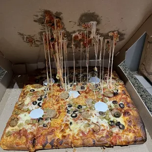 a pizza with olives and mushrooms