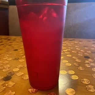 a red drink in a plastic cup