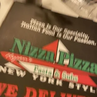 a pizza delivery sign on a table