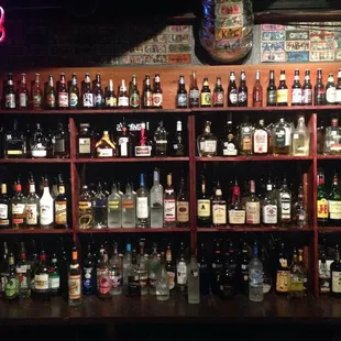 a shelf full of liquor bottles