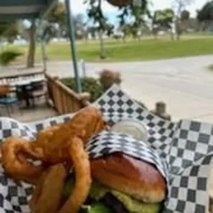 a sandwich and onion rings on a checkered paper