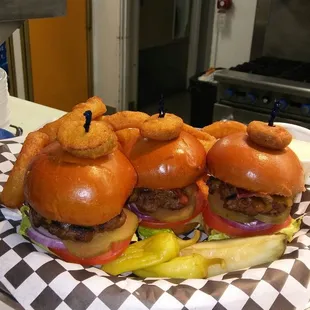 a basket of hamburgers with onion rings