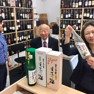 a woman holding a bottle of sake