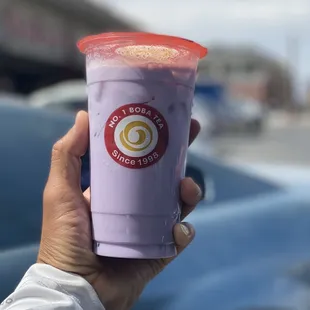 a hand holding a cup of boba