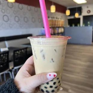 a hand holding a cup of boba