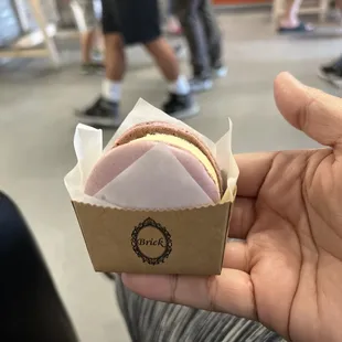 a hand holding a sandwich