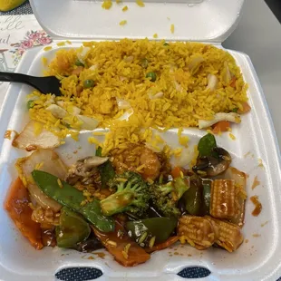 a take out container with rice and vegetables