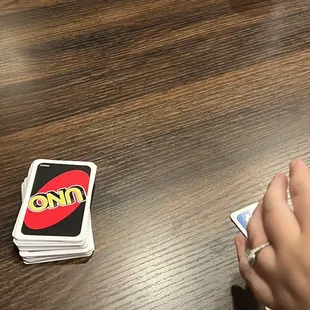 a person sitting at a table playing uno