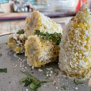 Corn the cob, topped with mayonnaise, tajin, queso cotija, and lime juice.
