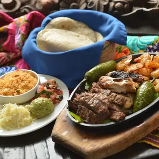 Fajitas for Two: Steak, Chicken Breast and Shrimp served with fresh guacamole, cheese and rice