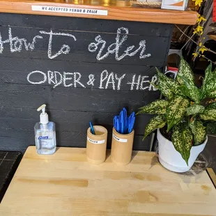 a wooden table with a sign that says how to order order and day here