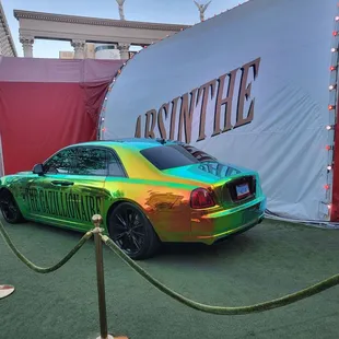 a colorful car parked in front of a sign
