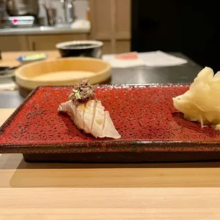 a red plate with sushi on it